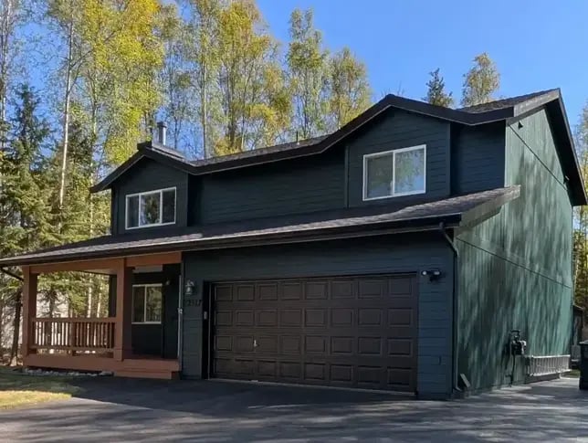 Exterior painting project showcasing a dark green house